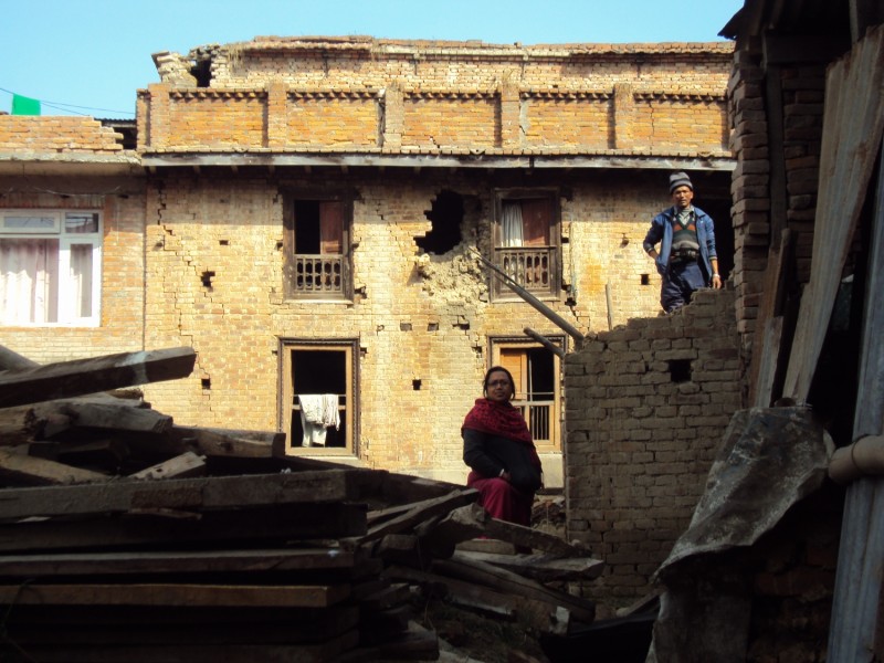 Leomlott épület és egykori lakói a Katmandutól 8 kilométerre fekvő Khokanában. A Newari kisebbség által lakott faluban a földrengés miatt összesen 700 ház omlott össze és 800 családot kellett kitelepíteni.